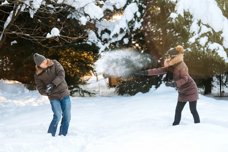 男孩和女孩在冬天的户外散步，玩雪球和雪橇