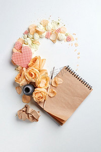 墨水井与笔记本和心与花在白色背景与空间的文字。玫瑰和心与笔记本