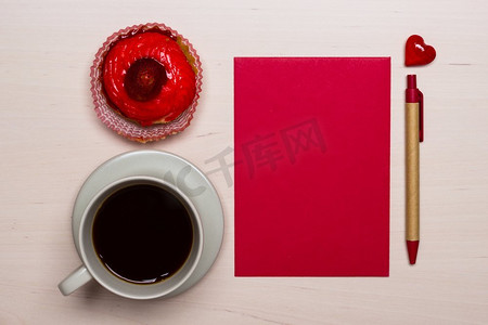 咖啡杯甜蛋糕纸杯蛋糕和红色纸空白与笔在木表面，顶视图复制空间文本