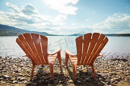 国朝山水插画摄影照片_两把木椅放在湖边，面朝水。