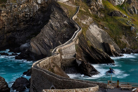 巴斯塔基亚老城摄影照片_圣胡安德Gaztelugatxe，它的中世纪楼梯和桥在日出，西班牙巴斯克地区。圣胡安德天然气工业股份公司