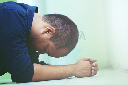 沮丧的人低着头,双手抱在地板上.男孩头发