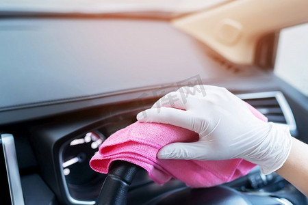 防止灰尘摄影照片_工作人员正在车内进行清洁，以防止病毒感染。