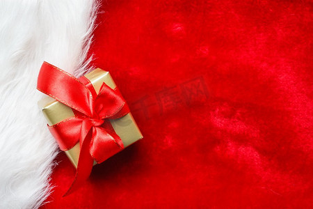 周年福礼摄影照片_节日，礼物，圣诞节的概念。小金盒与礼品系在红色背景装饰弓