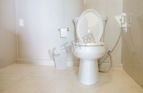 浴室地板摄影照片_白色马桶碗在浴室