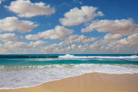 海滩上的蓝色波浪。模糊的背景和阳光斑点。戏剧性的自然背景。
