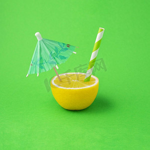 创造性的食品健康饮食概念照片柠檬饮料饮料果汁鸡尾酒有伞和稻草在绿色背景。
