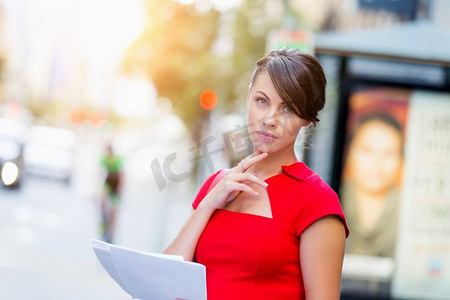 外面是女商人的肖像。身穿红色连衣裙的女商人手持文件的肖像