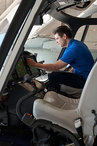 男性航空工程师与飞行员在直升机驾驶舱工作