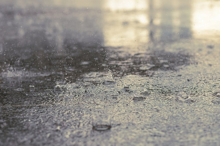 雨滴在水中沉重的黑色阴影和黑暗天空的反射在城市的沥青阴影。秋季高对比度