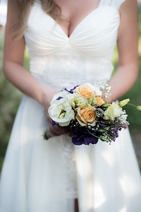 新娘手持印有紫色花朵的结婚花束