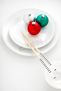 一家日本寿司店菜单上的创意盘子，上面装饰着圣诞球和筷子。