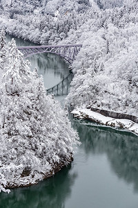 冬季景观积雪覆盖树木，火车过河过桥