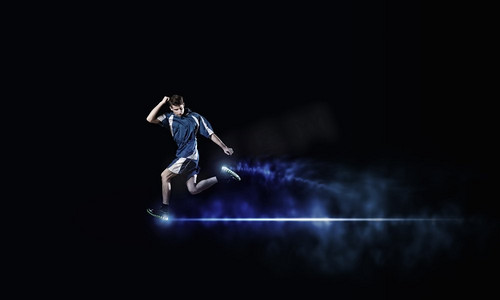 蓝色运动服摄影照片_全速前进。穿着蓝色运动服的奔跑男子在黑色背景下
