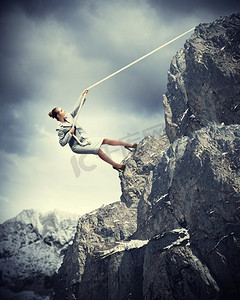 女商人登山。女商人用绳子攀登陡峭的山峰