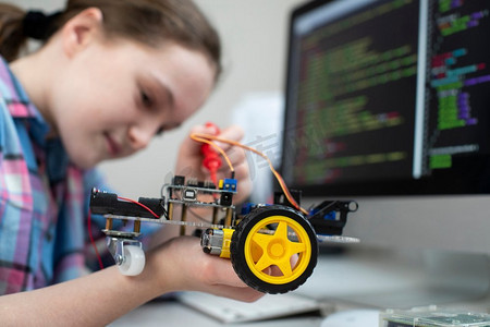 女学生在学校科学课上建造机器人车