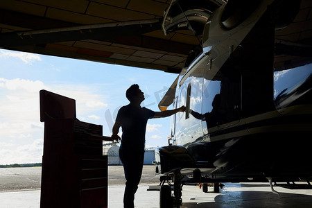 商业航天摄影照片_在机库工作的男航空工程师的剪影