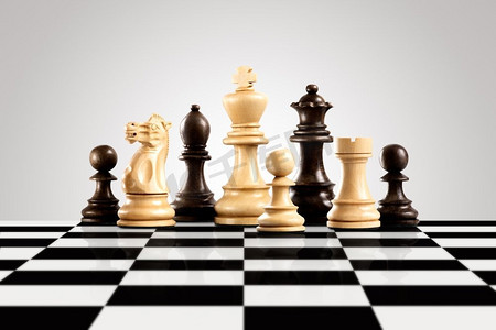 战场人物摄影照片_战略和领导理念；黑白木质棋子人物站在棋盘上准备下棋。
