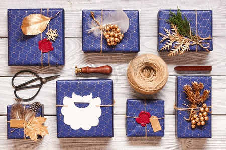 创意包装和装饰的圣诞礼物在白色木制背景的盒子里。从上面俯瞰。平躺着。