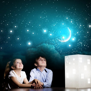 夜色摄影照片_夜里做梦。可爱的小男孩和小女孩看着房子的模型