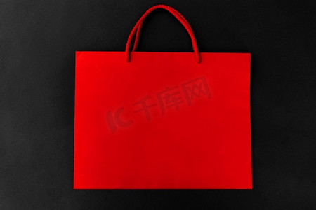 销售，消费主义和出口概念—在黑色背景的红色购物袋。红色购物袋在黑色背景
