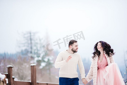 一个穿着裘皮大衣的新娘和未婚夫在喀尔巴阡山脉中