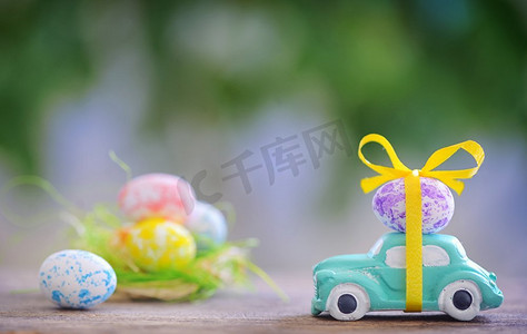 绿色的玩具摄影照片_春天里载着复活节彩蛋的玩具车