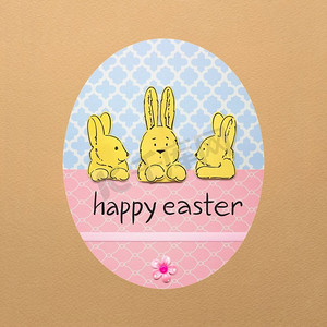 创意复活节概念照片，三只兔子在一个彩色彩蛋中，彩蛋是棕色背景下的纸。