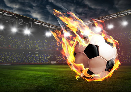游戏火焰摄影照片_体育场上正在燃烧的足球。足球或体育场里的足球着火了