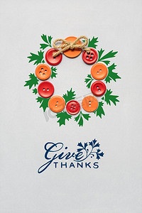 感恩节创意概念照片，由灰色背景上的纽扣制成的花环。