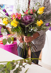 花商用五颜六色的花朵制作时尚的花束。花商制作花束