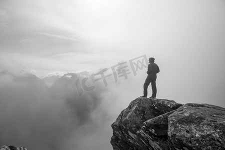 攀岩男孩摄影照片_山上悬崖上的人。徒步旅行的场景。