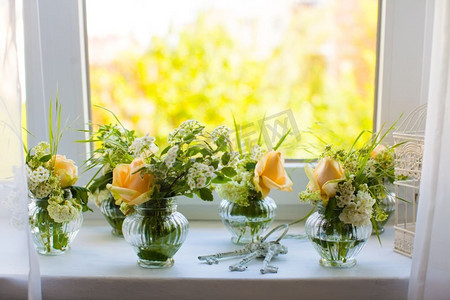 鸟笼玫瑰摄影照片_窗台上挂着一束束美丽的玫瑰和几把旧钥匙。房间的白色装饰