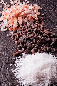 矿物山脉摄影照片_各种盐类，粉色喜马拉雅山脉和黑色与海盐的板岩背景。各种类型的盐类