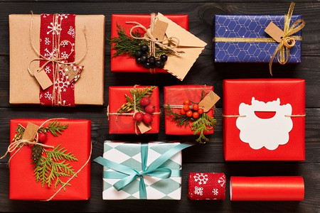 小山丘背景摄影照片_创造性地包装和装饰圣诞节礼物在箱子在黑暗的木背景顶视图从上面.平放。 