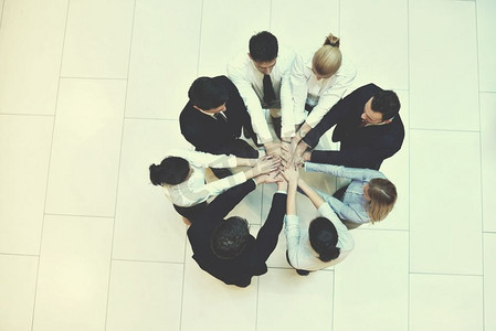商务人士团体携手合作，在圆圈中保持团队精神，代表友谊和团队合作的概念