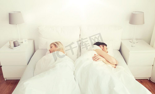 人、关系困难、冲突和家庭观念--夫妻在家中背靠背睡在床上。在家中睡在床上的夫妻