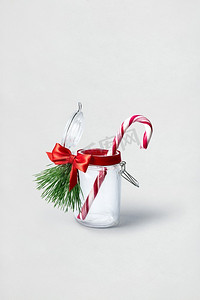 白色背景瓶中圣诞糖果的创意概念照片。