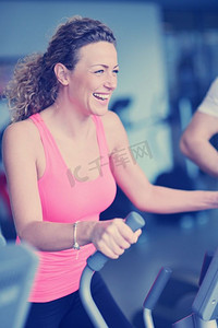 运动，健身，生活方式，技术和人的概念-微笑的女人在健身房的跑步机上锻炼。女性在健身房的跑步机上锻炼