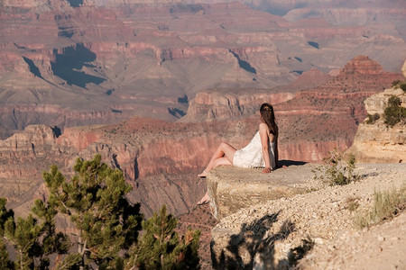坐在岩石边缘的大峡谷游客，美国亚利桑那州