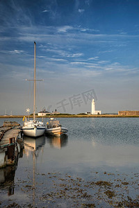 赫斯特用船和灯塔吐出码头的平静风景形象。风景画。赫斯特码头与船只和灯塔在日落时的景观图
