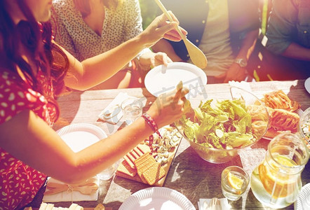 休闲、度假、饮食、人与食的概念-快乐的朋友在夏日聚会上共进晚餐。快乐的朋友在夏日聚会上共进晚餐