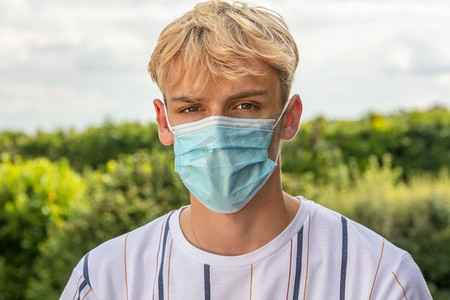 在冠状病毒新冠肺炎病毒大流行期间，十几岁的男童戴着口罩外出