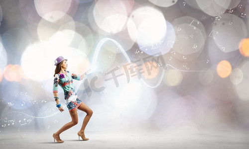 跳舞的女人。身着彩色连衣裙和帽子的年轻女子在波克背景下翩翩起舞