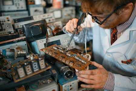 奇怪的科学家焊接芯片，在实验室测试。电子测试工具的背景实验室设备、工程车间