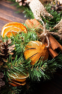 绿色环保装饰摄影照片_圣诞芳香环保花环。圣诞芳香生态花环，配上干橙子和肉桂棒，特写细节