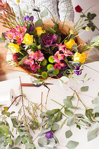 五颜六色花摄影照片_花商用五颜六色的花朵制作时尚的花束。花商制作花束