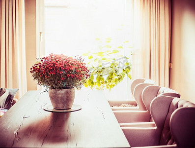 漂亮的客厅，靠窗的餐桌上有一簇簇菊花。秋季家装