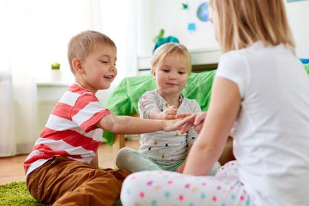 童年、休闲和家庭概念-快乐的小孩子在家里玩石头-剪刀-布游戏。孩子们在家里玩石头剪刀布游戏