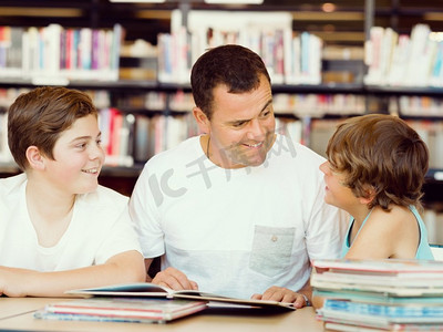 父亲带着儿子在图书馆里看书。父亲和儿子在图书馆